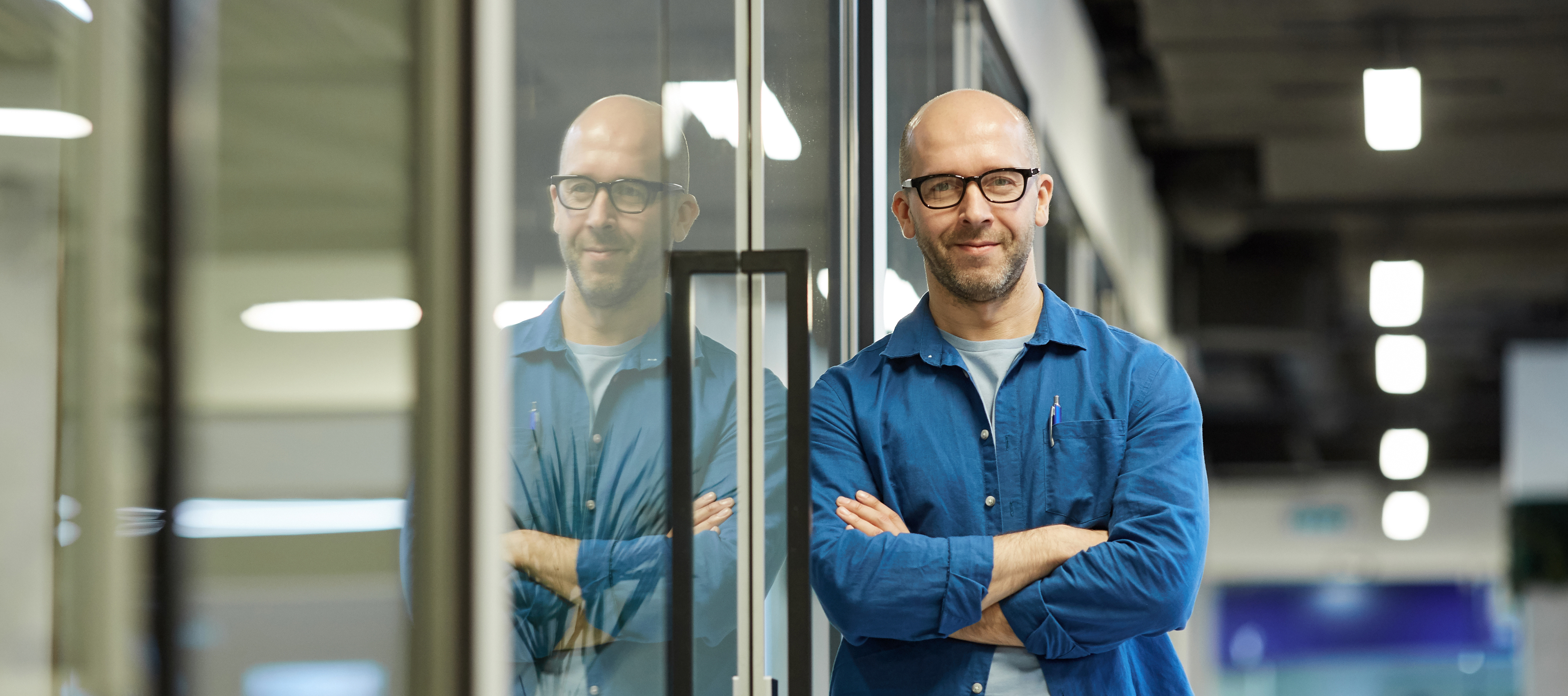 mężczyzna oparty o przeszklone drzwi